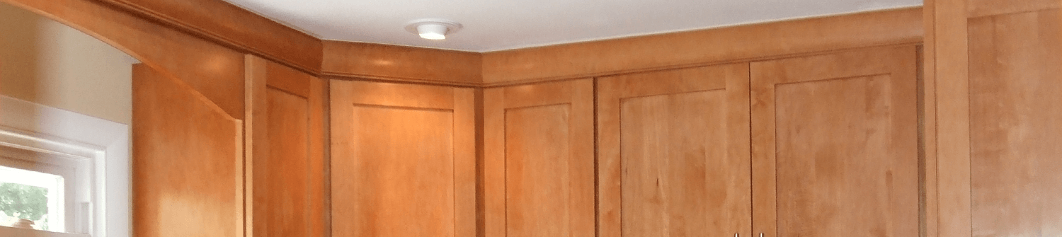 solid oak kitchen cabinets that reach the ceiling with accent lighting